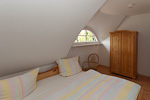 Schlafzimmer mit lauschiger Dachschräge in dem Ferienappartment auf Rügen, Moisselbritz